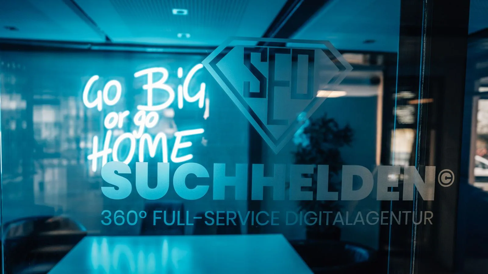 Beleuchteter Suchhelden-Schriftzug „Go big or go home“ an der Glaswand in Osnabrück Beleuchteter Suchhelden-Schriftzug „Go big or go home“ an der Glaswand in Osnabrück
