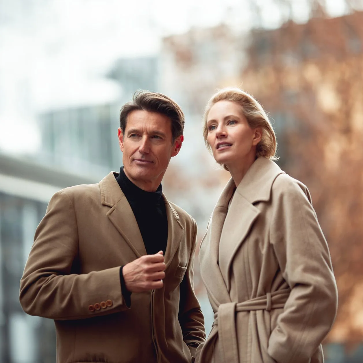 Mann und Frau mittleren Alters, die modern gekleidet durch die Stadt spazieren Mann und Frau mittleren Alters, die modern gekleidet durch die Stadt spazieren