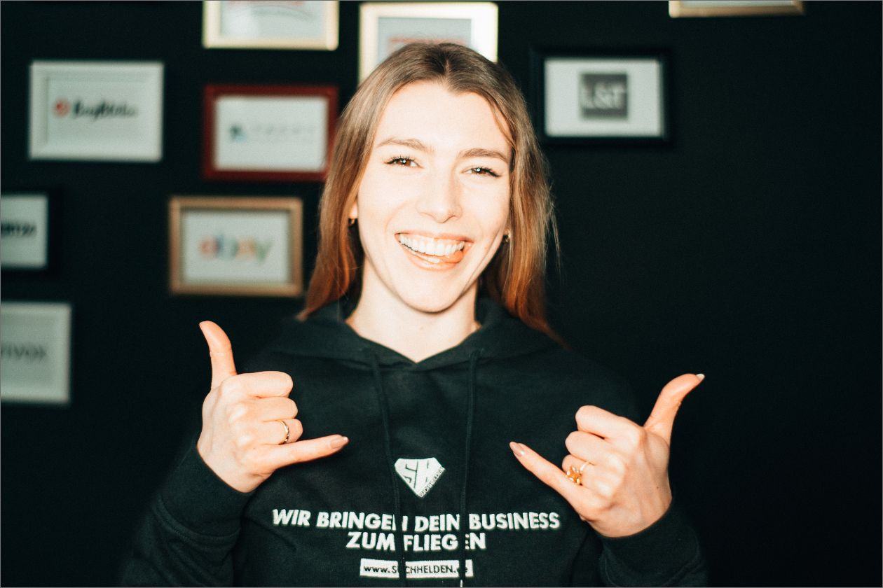 Liesa Marie Bockholt vor schwarzem Hintergrund mit gerahmten Logos.